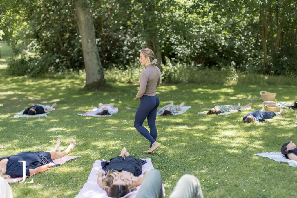 Guests participating in a nature-inspired wellness session in a shaded woodland clearing