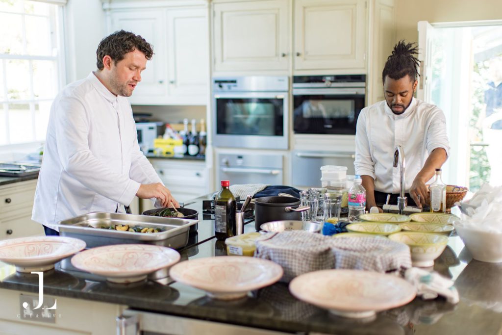 Chefs preparing gourmet dishes at Belmond Secret Retreat, Knepp Estate, showcasing slow luxury hospitality