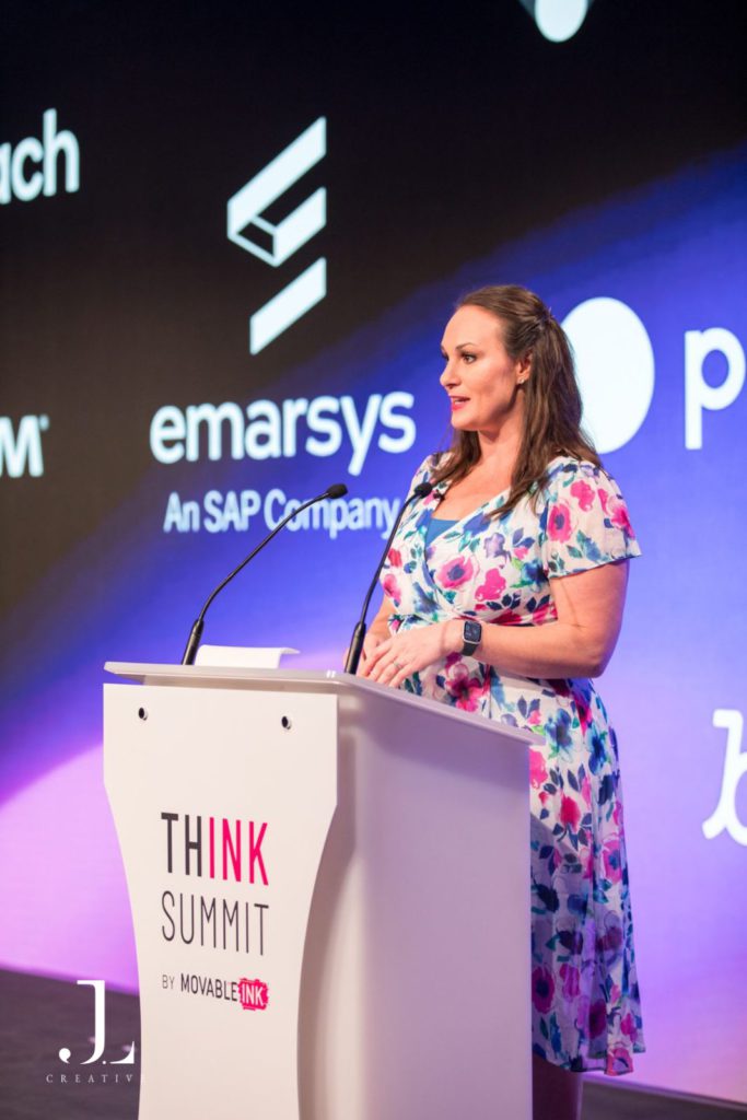 speaker on stage presenting to audience at tech conference