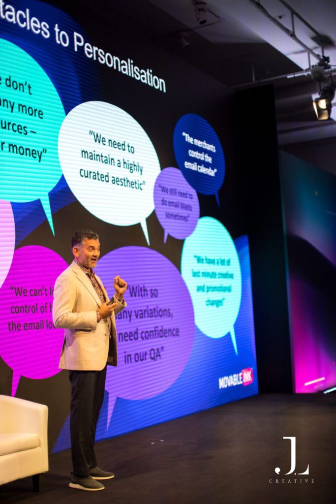 speaker on stage presenting to audience at tech conference
