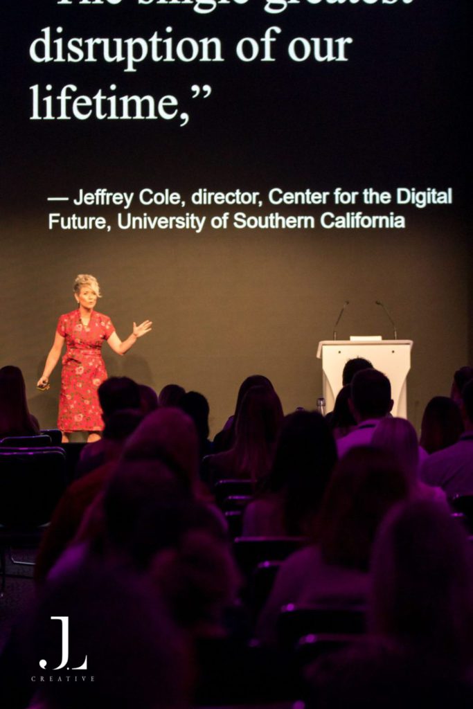 speaker on stage presenting to audience at tech conference