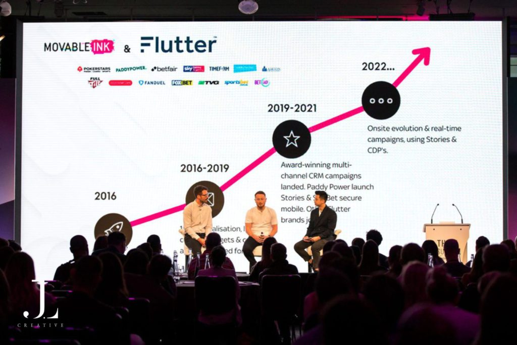 speakers on stage presenting to audience at tech conference