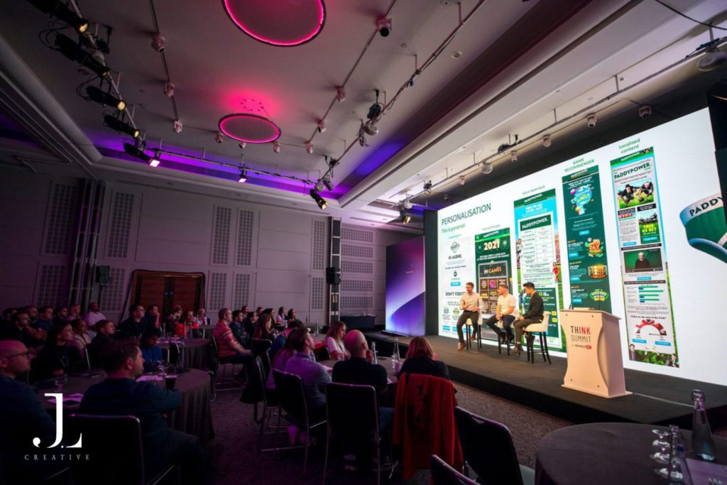 speakers on stage presenting to audience at tech conference