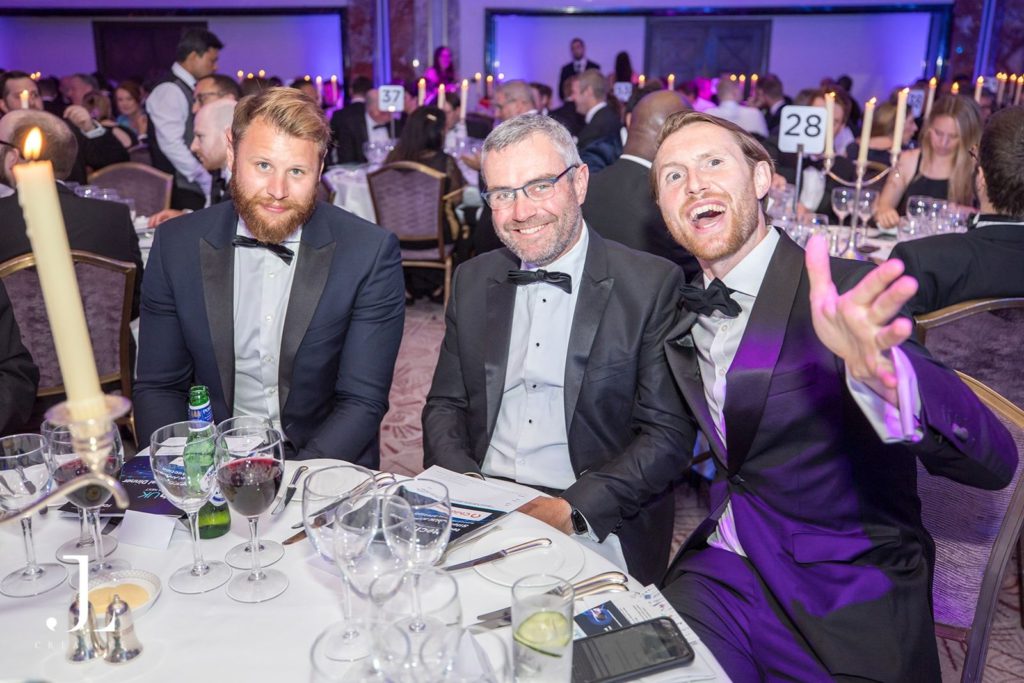 Candid photo of guests laughing at a candlelit corporate dinner table