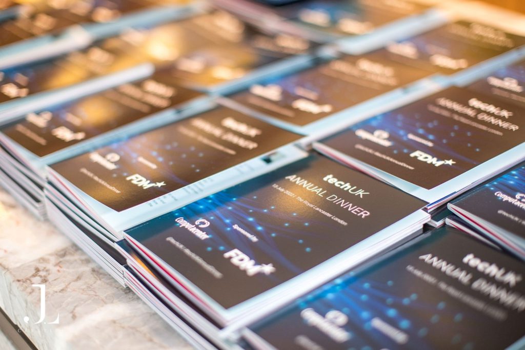 Close-up of TechUK Annual Dinner event programs on a surface
