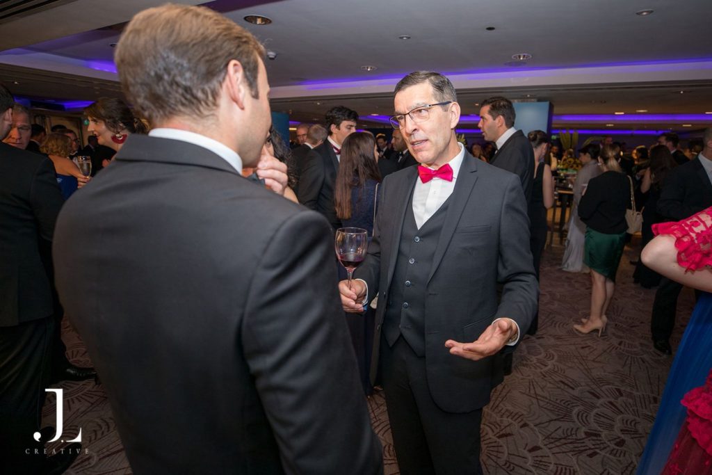 Two men in black tie networking at a corporate drinks reception