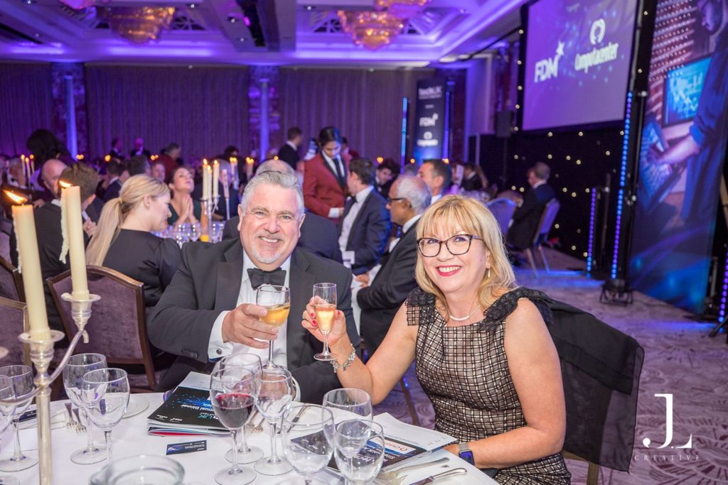 Candid photo of guests laughing at a candlelit corporate dinner table