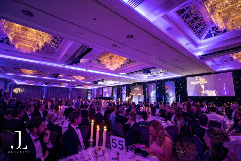 Wide-angle view of a TechUK awards dinner in a grand London ballroom