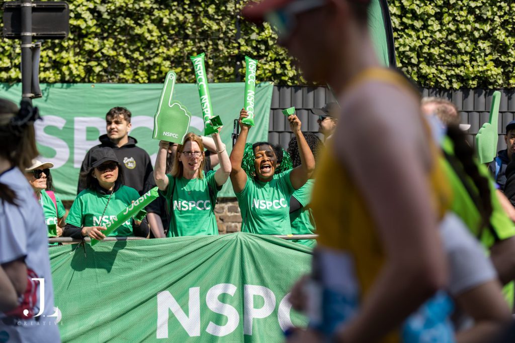 Volunteers cheering with banners at marathon charity event London