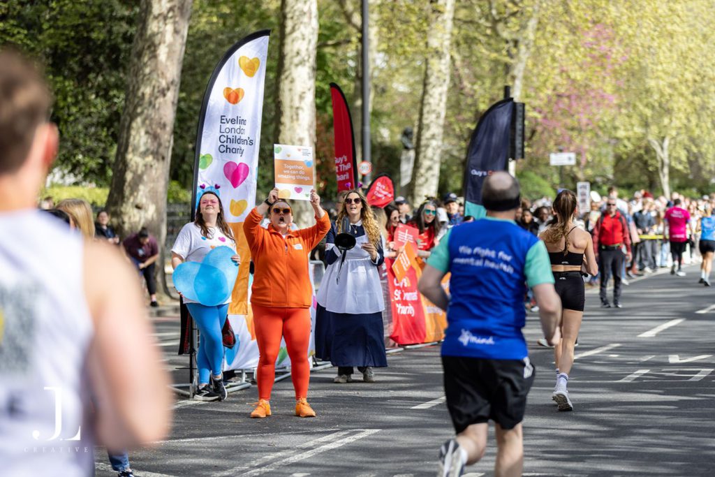 Volunteers cheering with banners at marathon charity event London