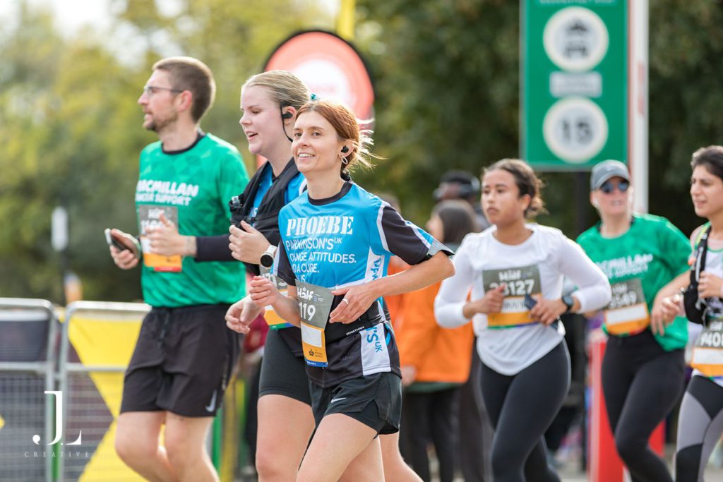A Parkinson’s UK fundraiser smiling while running the Royal Parks Half Marathon.