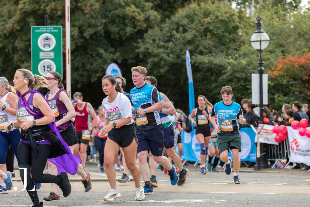 A Parkinson’s UK fundraiser smiling while running the Royal Parks Half Marathon.