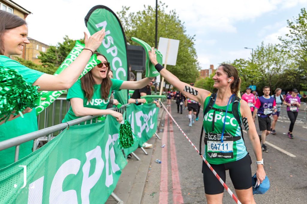 Charity cheer squad with banners and clappers at marathon event