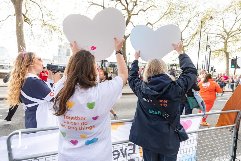 Volunteers cheering with banners at marathon charity event London