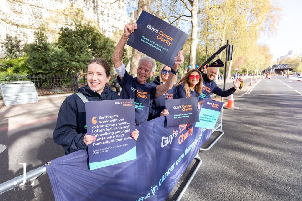 Volunteers cheering with banners at marathon charity event London