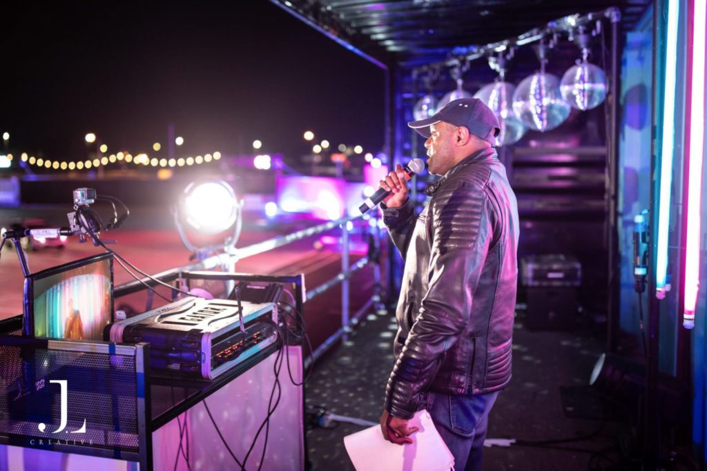 Professional host speaking into a microphone at an evening event