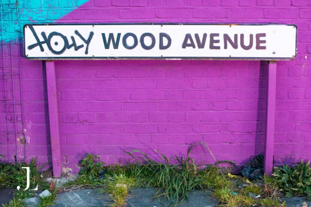 Purple brick wall with "Holly Wood Avenue" street sign, corporate event photography London.