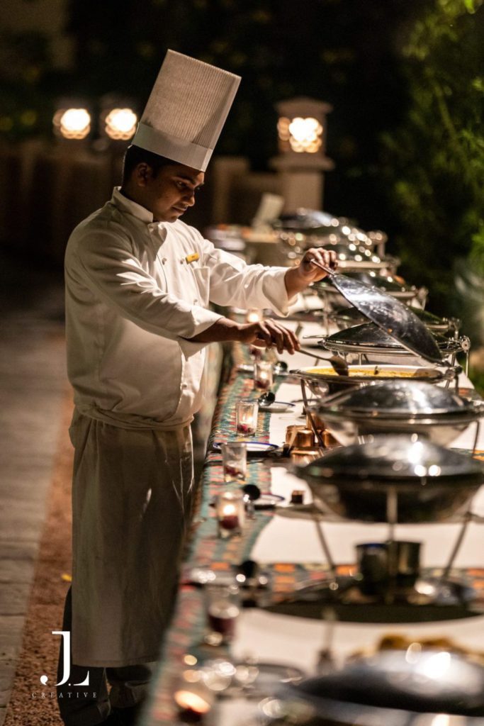 High-end event photography of a professional chef preparing a gourmet buffet at an exclusive evening celebration.