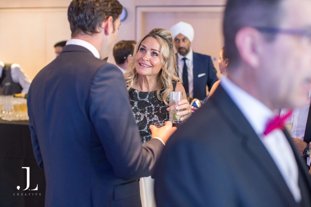 Discreet event photographer capturing genuine guest interactions during an elegant black-tie cocktail reception.