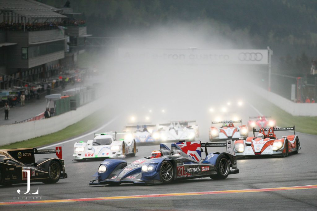 High-end event photography of endurance race cars on a misty track, captured by a professional event photographer.