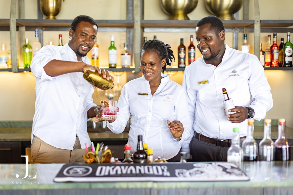 Friendly bartenders preparing cocktails at Daunara, captured for luxury hotel PR photography in Botswana.