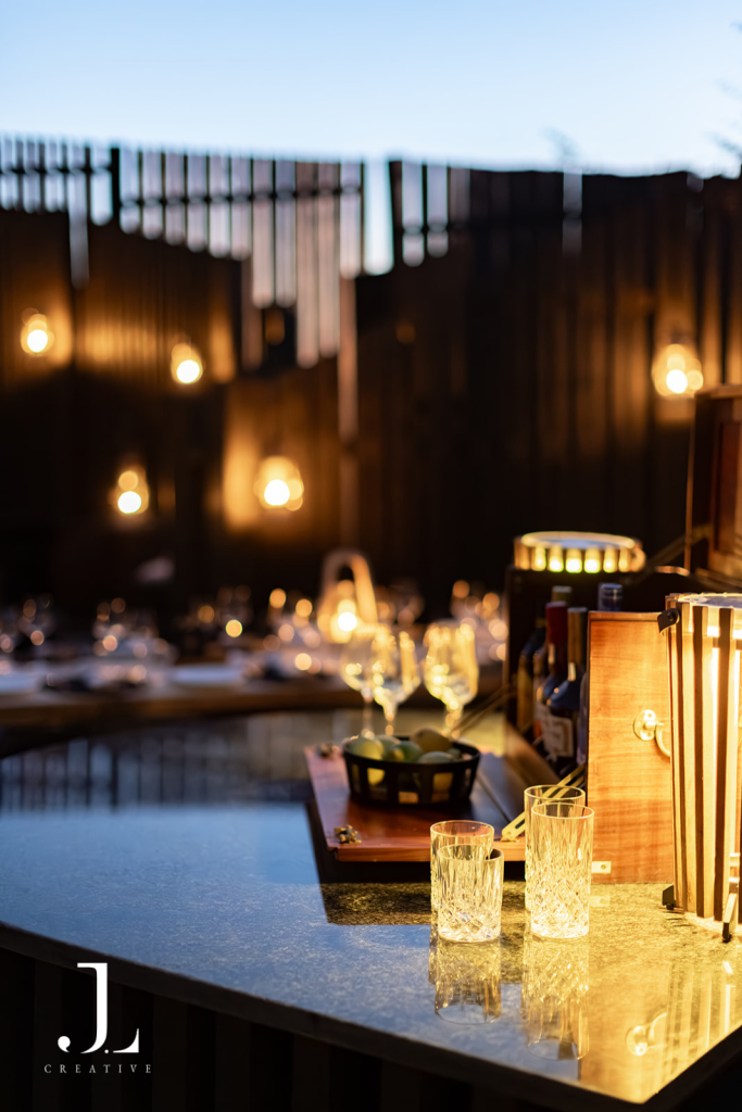Warm outdoor bar set up at twilight, showcasing luxury hospitality photography for Daunara Safari Camp.
