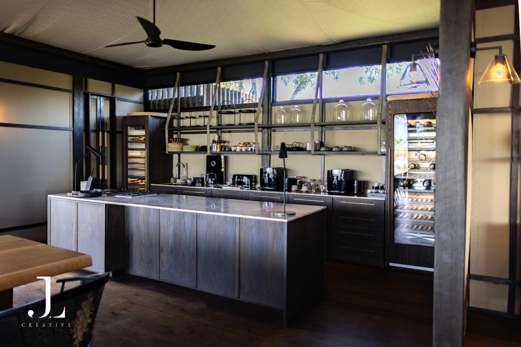 Modern open-plan kitchen and bar island, capturing interior luxury safari lodge photography at Daunara.