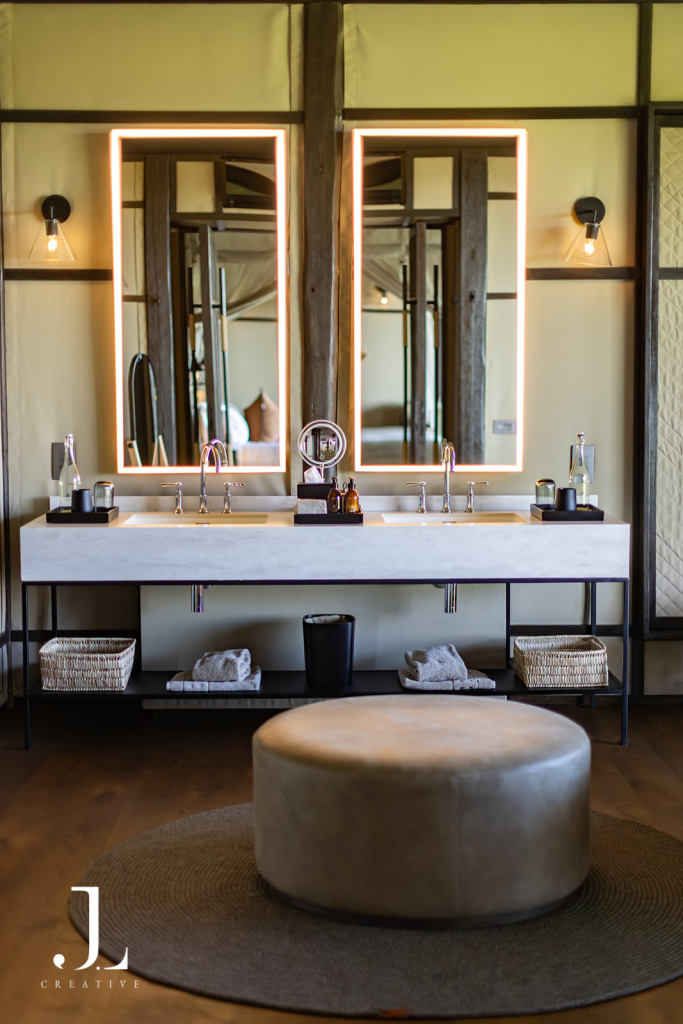 Elegant ensuite bathroom with dual illuminated mirrors, featuring safari camp photography Botswana at Daunara.